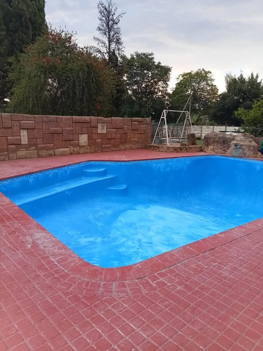 Curved freeform pool with a rock waterfall feature